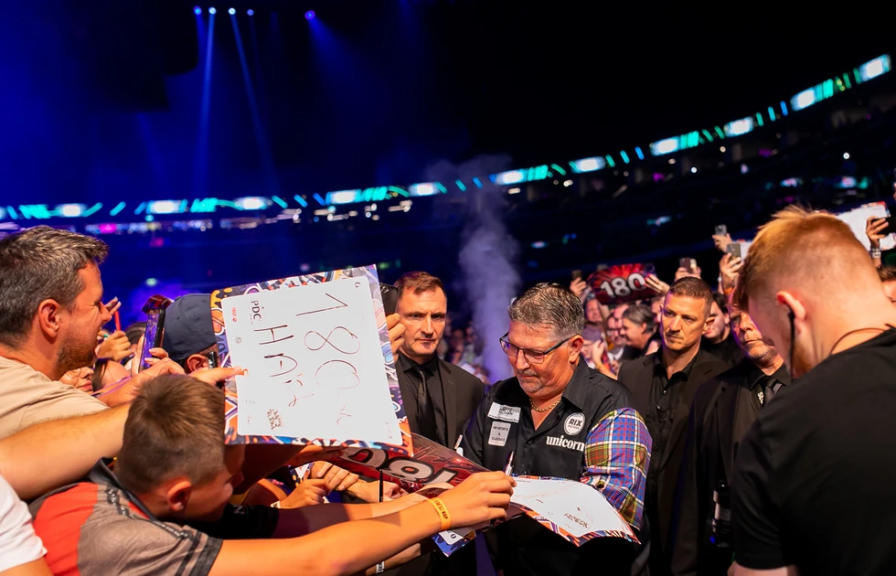 Gary Anderson schreibt nach seinem Auftritt bei der Hungarian Darts Trophy 2026 Autogramme für Fans in Budapest.