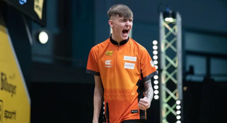 Bradley Brooks jubelt während eines Darts-Turniers im orangefarbenen Trikot.