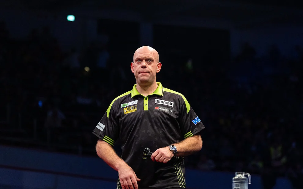 Michael van Gerwen steht bei der Darts-EM 2026 mit Darts in der Hand auf der Bühne und blickt konzentriert nach vorne.