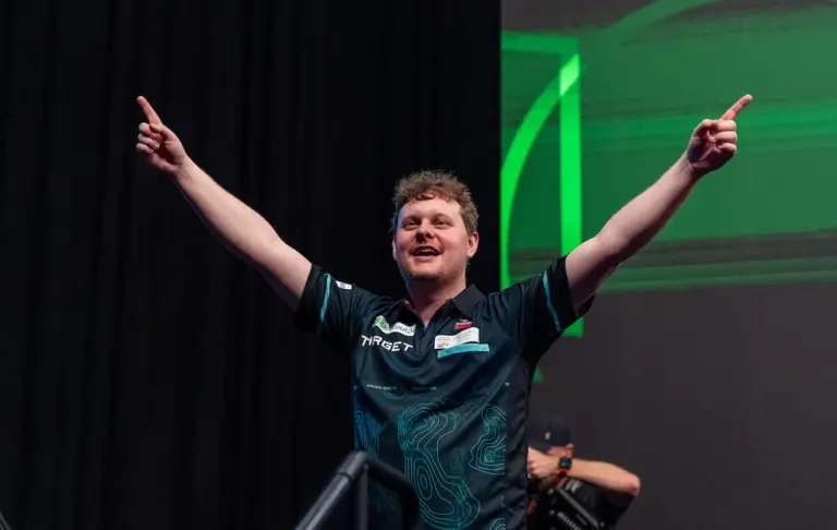 Kevin Doets jubelt bei der Darts-EM 2026 mit ausgebreiteten Armen und zeigt mit beiden Zeigefingern nach oben.