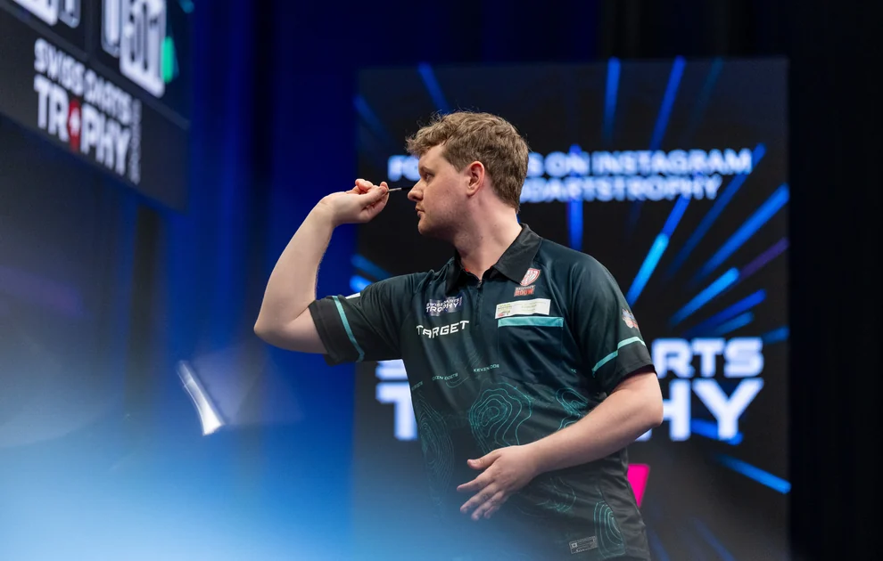 Kevin Doets mit erhobenem Dartarm auf der Bühne der Swiss Darts Trophy 2026.