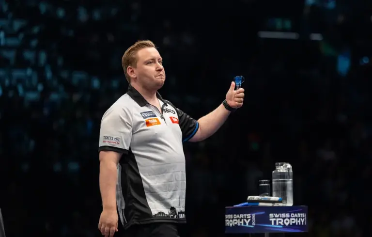 Martin Schindler mit Darts auf der Bühne der Swiss Darts Trophy 2026.